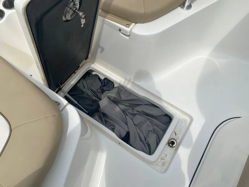 Slide: The Image of Open storage compartment on 2019 Key West 239 FS boat with fabric inside. - 13