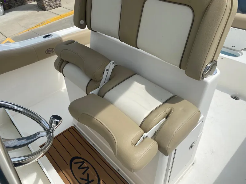 Slide: The Image of 2019 Key West 239 FS boat seat with beige and white upholstery, featuring a wooden floor mat. - 15