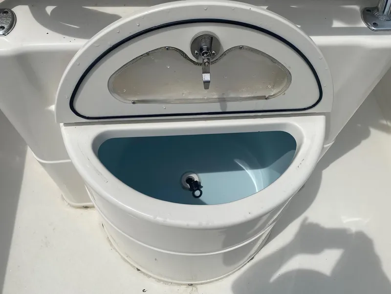 Slide: The Image of Livewell on a 2019 Key West 239 FS boat, featuring a faucet and blue interior. - 19