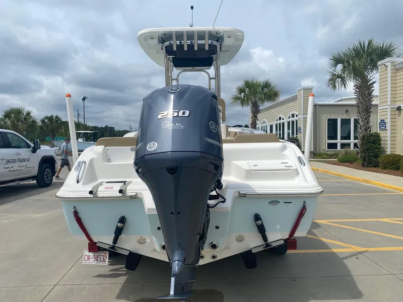 Slide: The Image of 2019 Key West 239 FS boat with Yamaha 250 engine, parked outdoors near palm trees. - 3
