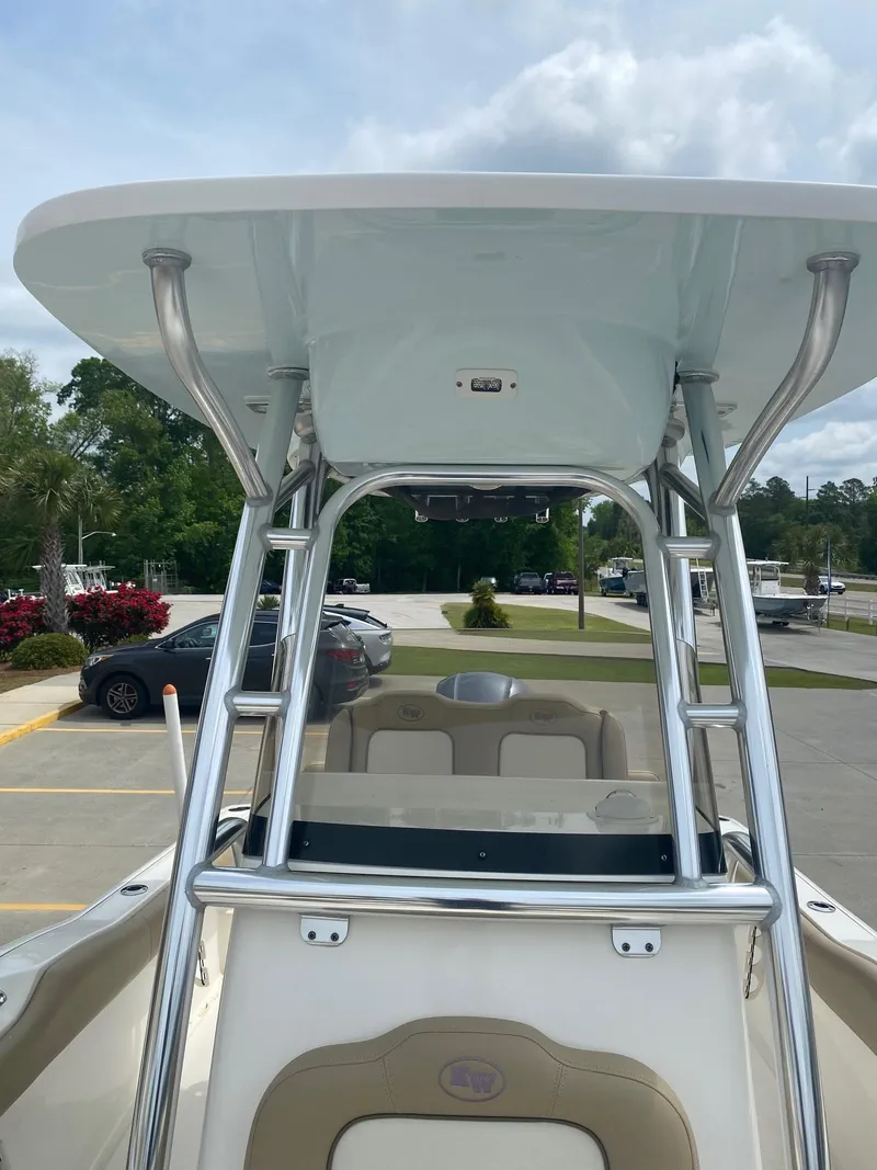 Slide: The Image of 2019 Key West 239 FS boat with T-top and stainless steel frame in a parking lot. - 9