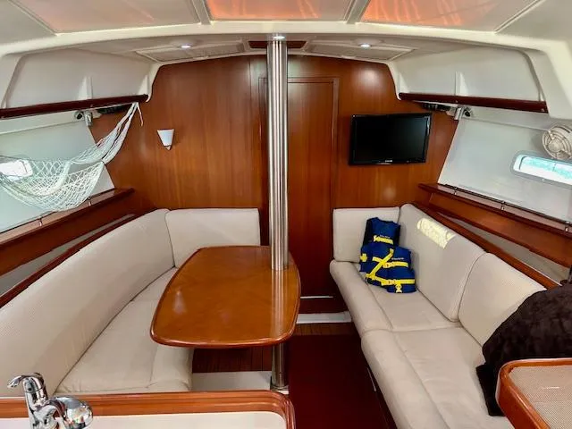 Slide: The Image of Interior of 2007 Beneteau 373 sailboat with cozy seating and wooden table. - 10