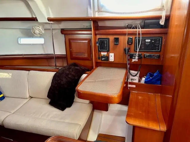 Slide: The Image of Interior of 2007 Beneteau 373 sailboat with navigation station and cozy seating area. - 11