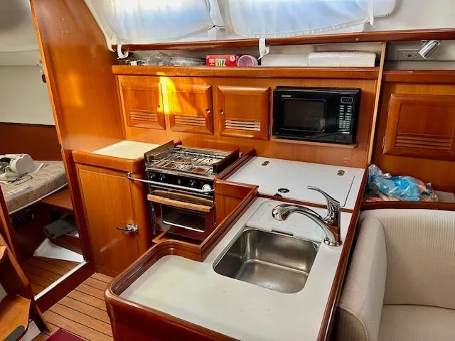 Slide: The Image of 2007 Beneteau 373 yacht kitchen with stove, sink, and microwave. - 13