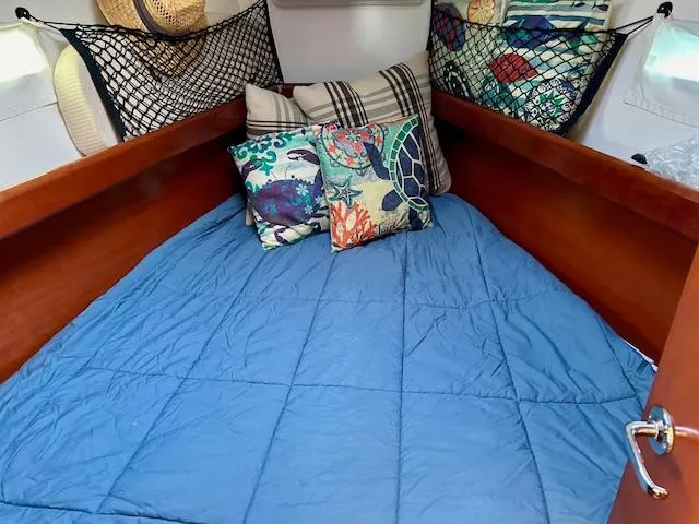 Slide: The Image of Cozy cabin interior of 2007 Beneteau 373 sailboat with colorful pillows and blue bedding. - 18