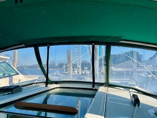 Slide: The Image of Interior view of 2007 Beneteau 373 sailboat with green canopy and marina background. - 27