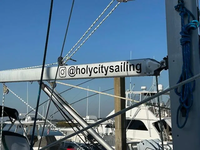 Slide: The Image of Beneteau 373 sailboat mast with "@holycitysailing" Instagram handle, marina background. - 4