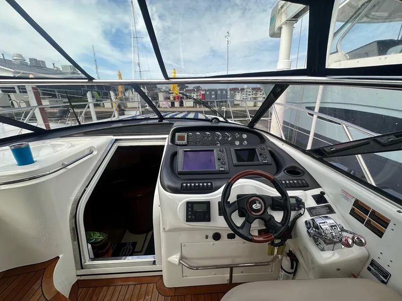 Slide: The Image of Cockpit of 2001 Sunseeker Camargue 44 yacht with steering wheel and navigation controls. - 12