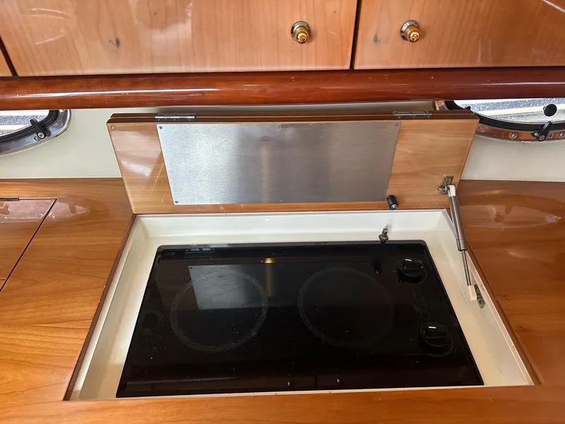 Slide: The Image of Sunseeker Camargue 44 yacht kitchen with sleek stovetop, wooden cabinetry, and modern design. - 36