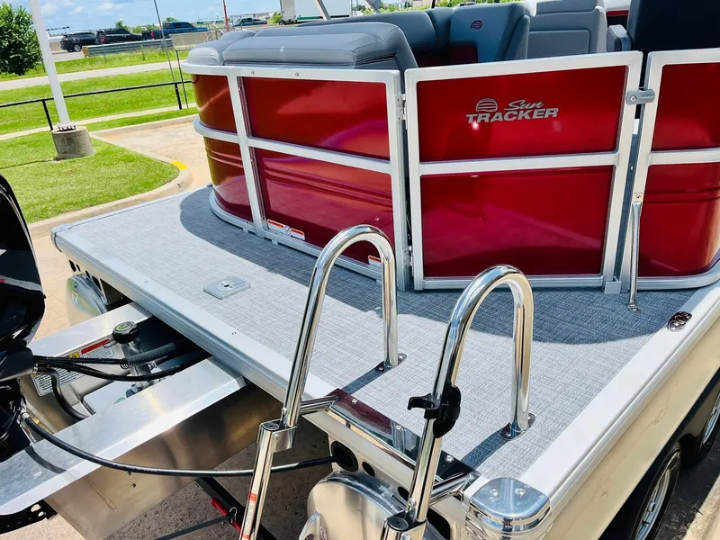 Slide: The Image of 2026 Sun Tracker Party Barge 20 DLX pontoon boat with red exterior and stainless steel ladder. - 10