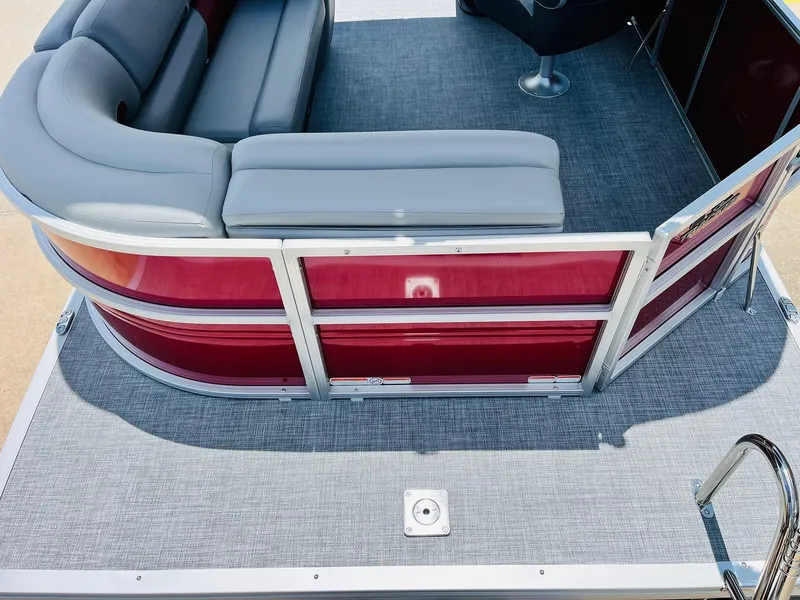 Slide: The Image of 2026 Sun Tracker Party Barge 20 DLX with red panels and gray seating on deck. - 12