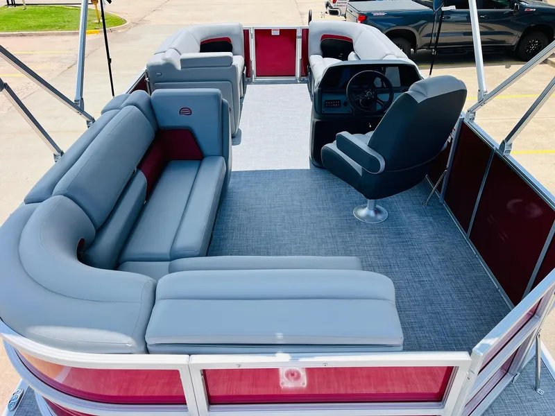 Slide: The Image of 2026 Sun Tracker Party Barge 20 DLX interior with gray seating and steering console. - 13