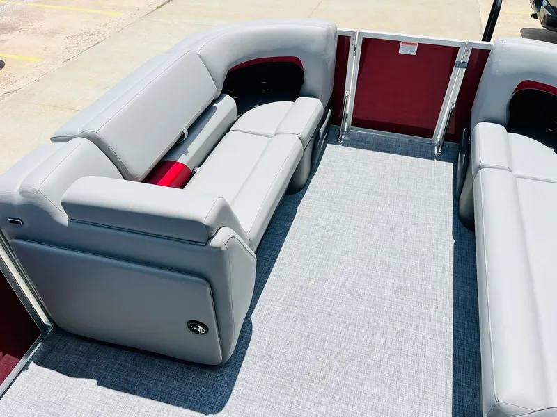 Slide: The Image of 2026 Sun Tracker Party Barge 20 DLX interior with gray seating and red accents. - 15