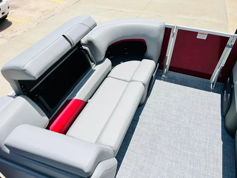 Slide: The Image of 2026 Sun Tracker Party Barge 20 DLX interior with gray seating and red accents. - 17