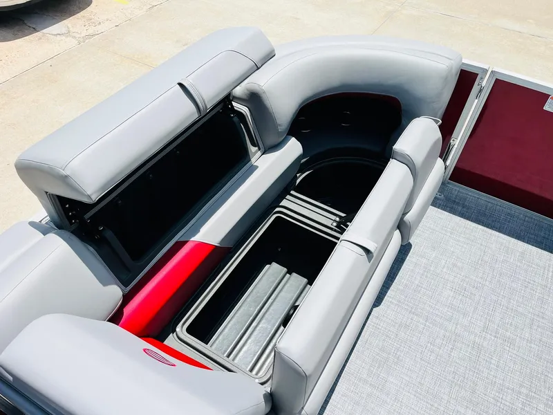 Slide: The Image of 2026 Sun Tracker Party Barge 20 DLX seating with storage compartments open. - 20