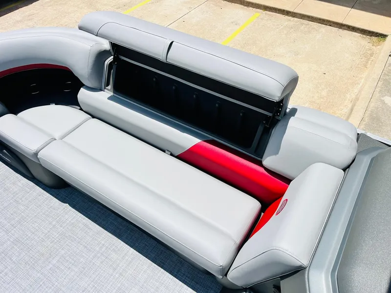 Slide: The Image of 2026 Sun Tracker Party Barge 20 DLX with open storage compartment and gray seating. - 22
