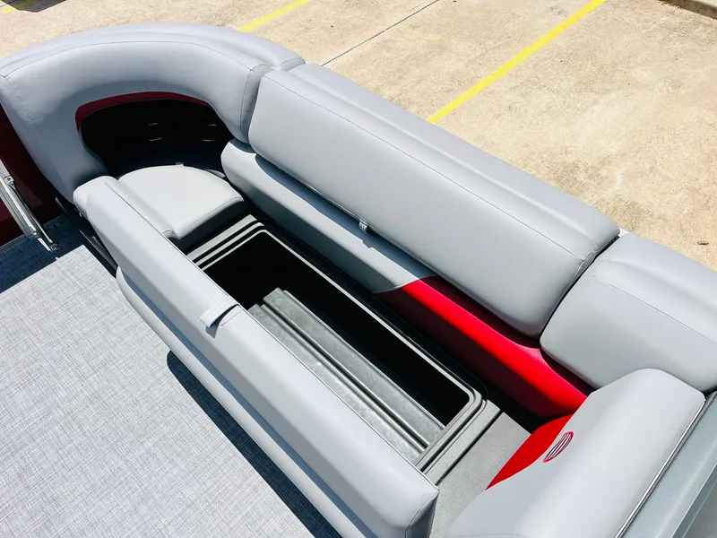 Slide: The Image of 2026 Sun Tracker Party Barge 20 DLX with open storage compartment and gray seating. - 23