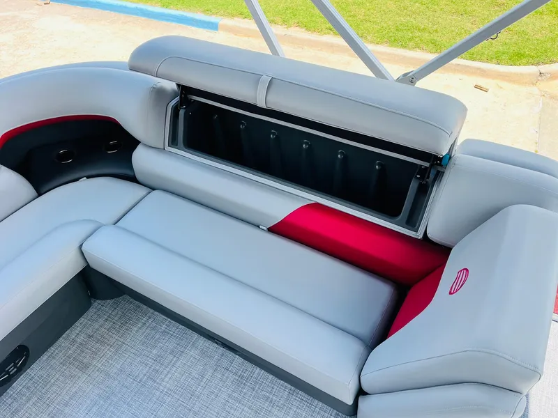 Slide: The Image of 2026 Sun Tracker Party Barge 20 DLX with open storage compartment and gray seating. - 32