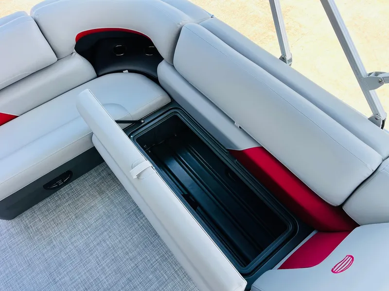 Slide: The Image of 2026 Sun Tracker Party Barge 20 DLX seating with storage compartment open. - 33