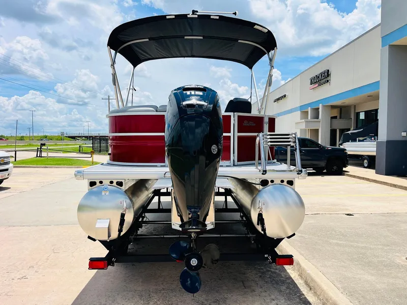 Slide: The Image of 2026 Sun Tracker Party Barge 20 DLX pontoon boat with outboard motor, parked outdoors. - 7