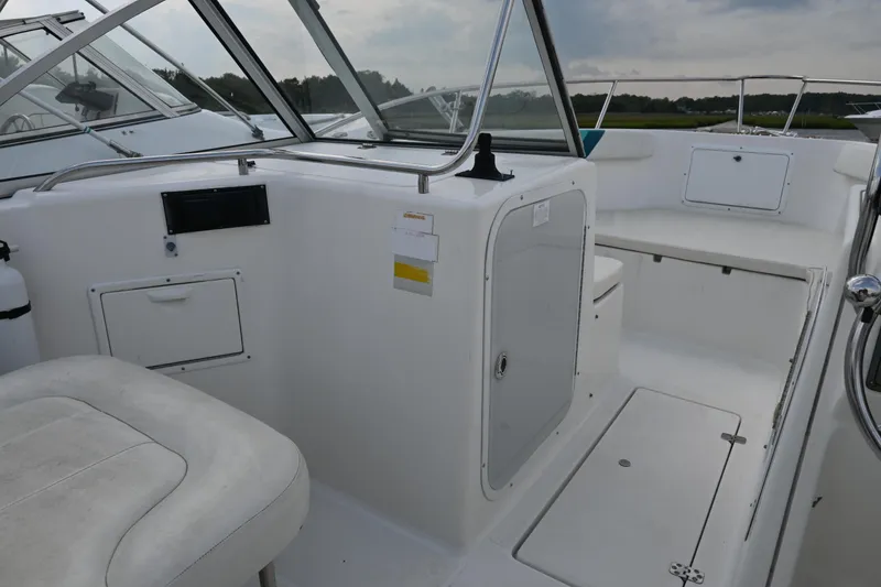 Slide: The Image of 1999 Aquasport 215 Dual Console boat interior with seating and storage compartments. - 11