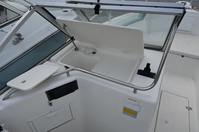Slide: The Image of 1999 Aquasport 215 Dual Console boat interior with open storage compartment. - 17