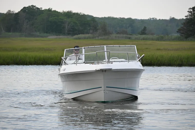 Slide: The Image of 1999 Aquasport 215 Dual Console boat cruising on a calm river. - 2
