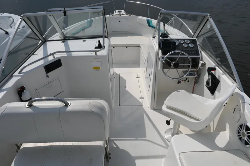 Slide: The Image of 1999 Aquasport 215 Dual Console boat interior with steering wheel and seating. - 8