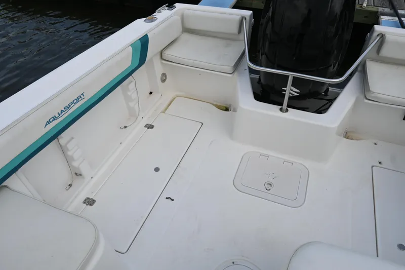 Slide: The Image of 1999 Aquasport 215 Dual Console boat interior with seating and storage compartments. - 9