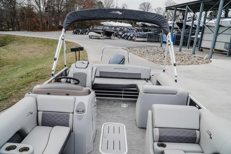 Slide: The Image of 2021 Bennington 22SSBXP pontoon boat with spacious seating and sleek design at a marina. - 11
