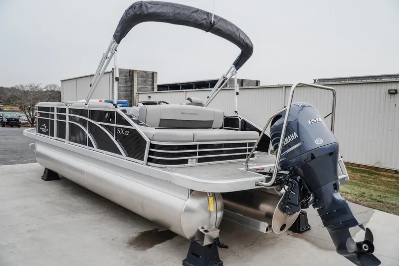 Slide: The Image of 2021 Bennington 22SSBXP pontoon boat with Yamaha 150 engine, parked outdoors. - 4