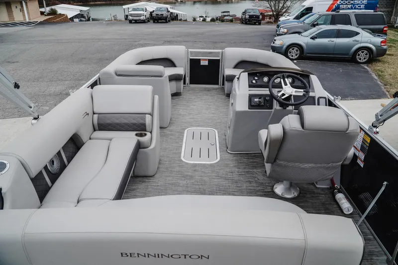Slide: The Image of 2021 Bennington 22SSBXP pontoon boat interior with plush seating and steering console. - 5