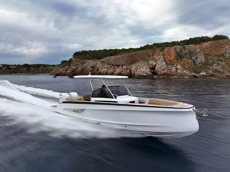 Slide: The Image of 2026 STERK 31 WB Super Sport boat cruising near rocky coastline under cloudy sky. - 16