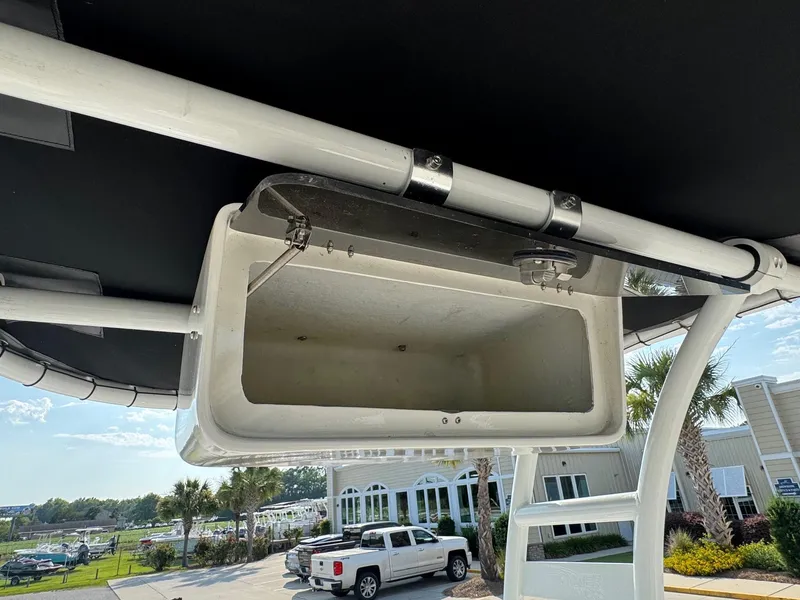 Slide: The Image of 2019 Bulls Bay 2000 boat storage compartment, open, with a view of a parking lot and palm trees. - 10