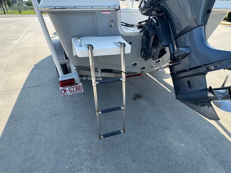 Slide: The Image of 2019 Bulls Bay 2000 boat with ladder and outboard motor, parked on concrete. - 22