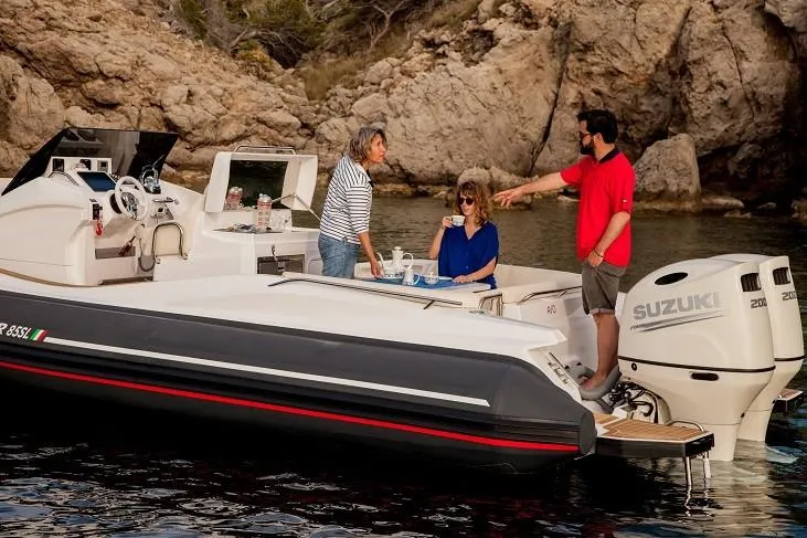 Slide: The Image of 2025 Zar Formenti 85 SL boat with Suzuki engines, people enjoying on deck near rocky shore. - 16