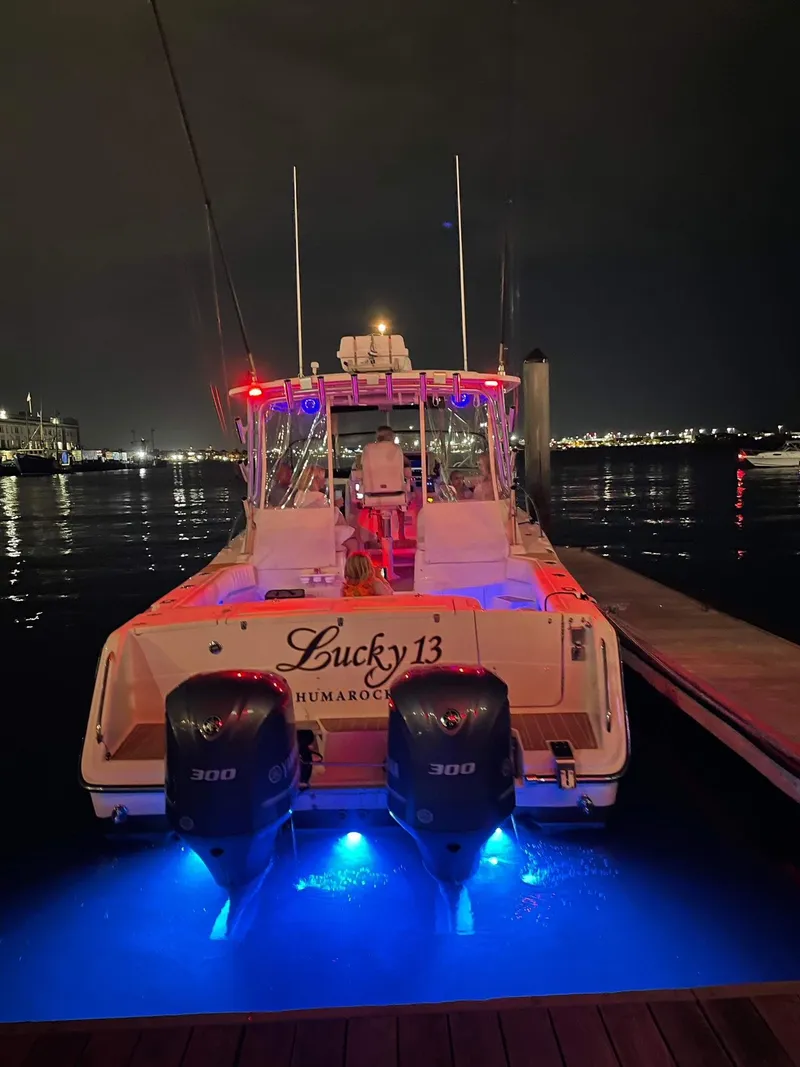 Slide: The Image of 2007 Grady-White Express 330 boat docked at night with illuminated blue lights. - 16