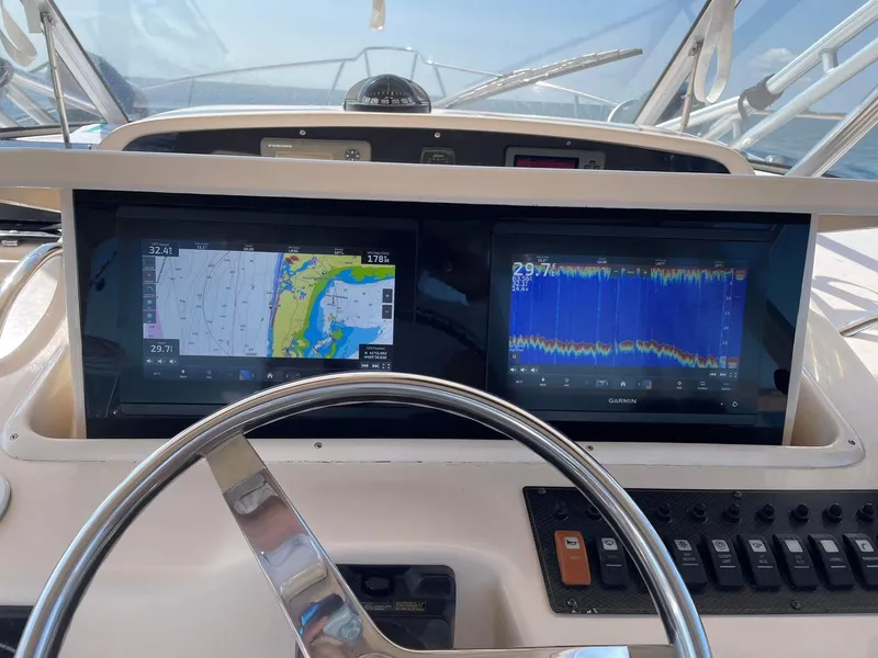 Slide: The Image of 2007 Grady-White Express 330 helm with dual Garmin displays and navigation controls. - 18