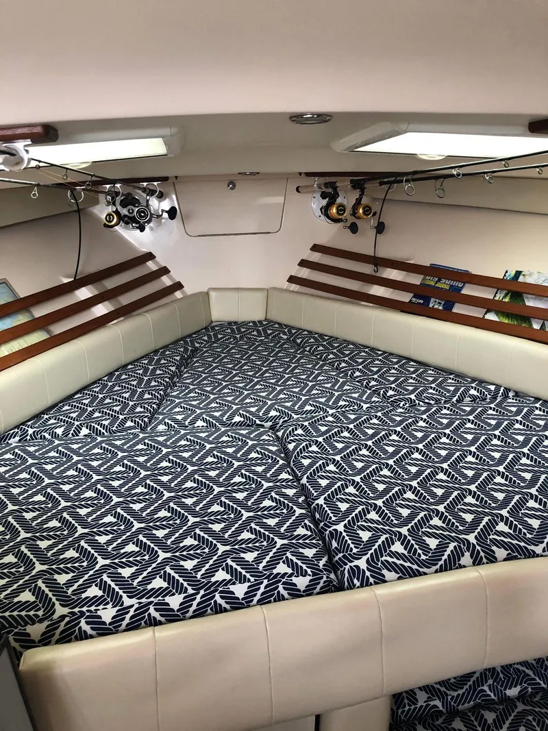 Slide: The Image of 2007 Grady-White Express 330 cabin interior with patterned bedding and fishing rods. - 21