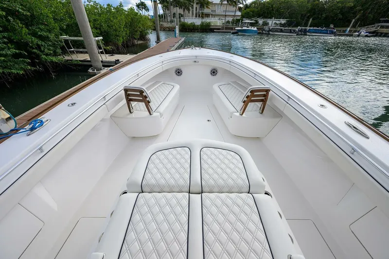 Slide: The Image of 2025 Valhalla Boatworks V-41 with luxurious seating, docked by lush greenery. - 37