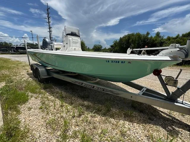 Slide: The Image of 2016 Blue Wave 2200 PureBay boat on trailer, parked outdoors under a partly cloudy sky. - 12