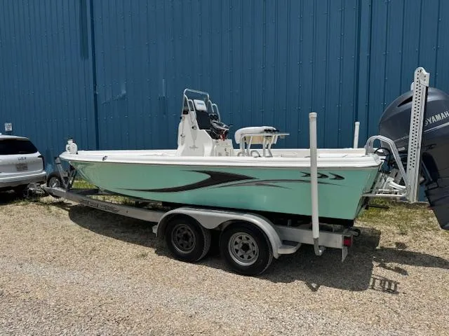 Slide: The Image of 2016 Blue Wave 2200 PureBay boat on trailer, parked beside a blue building. - 3