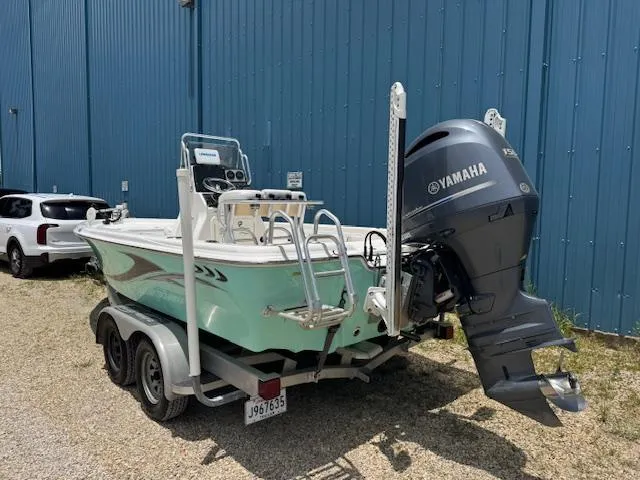 Slide: The Image of 2016 Blue Wave 2200 PureBay boat with Yamaha outboard motor, parked near a blue building. - 4