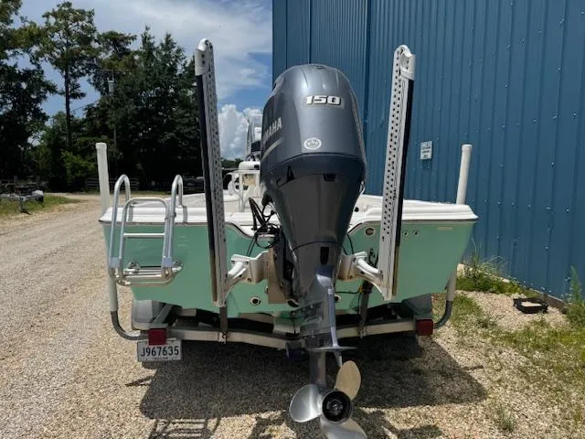 Slide: The Image of 2016 Blue Wave 2200 PureBay boat with Yamaha 150 engine, parked near blue building. - 5