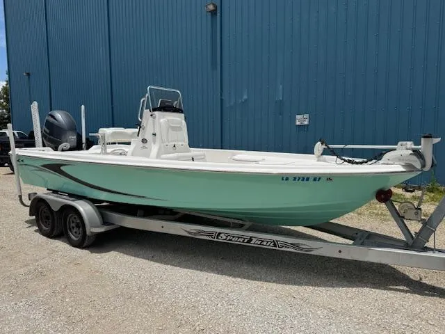 Slide: The Image of 2016 Blue Wave 2200 PureBay boat on trailer, parked by a blue building. - 9
