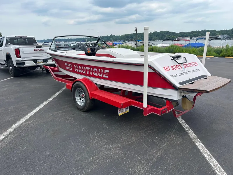 Slide: The Image of 1993 Correct Craft Ski Nautique boat on red trailer, parked near a lake with a GMC truck. - 3