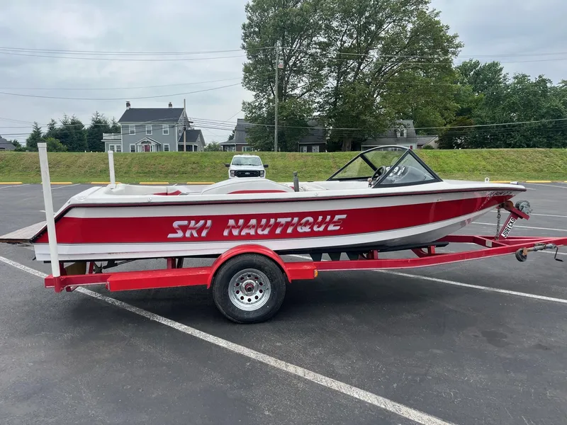 Slide: The Image of 1993 Correct Craft Ski Nautique boat on red trailer in parking lot. - 5