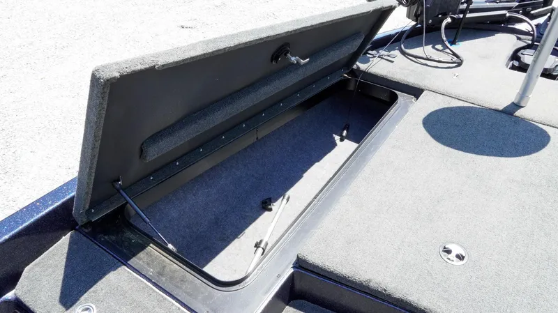 Slide: The Image of 2021 Skeeter ZX200 boat storage compartment open, showing interior space and carpeted finish. - 15