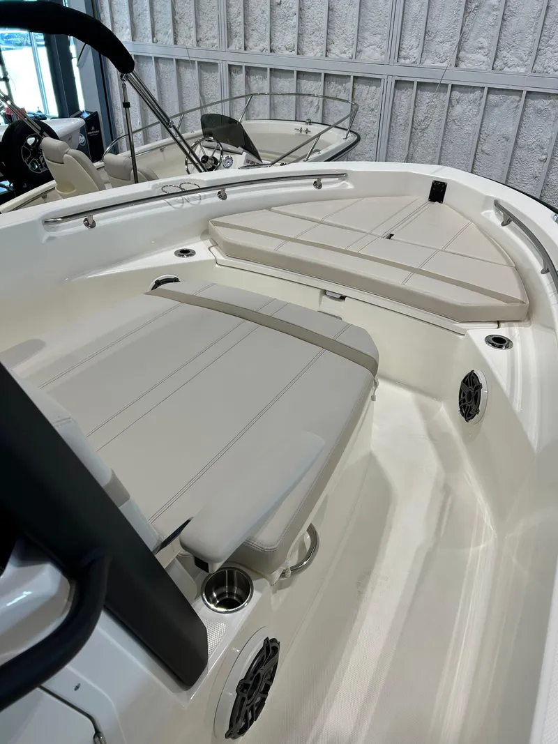 Slide: The Image of 2025 Boston Whaler 220 Dauntless boat interior with cushioned seating and cup holders. - 11