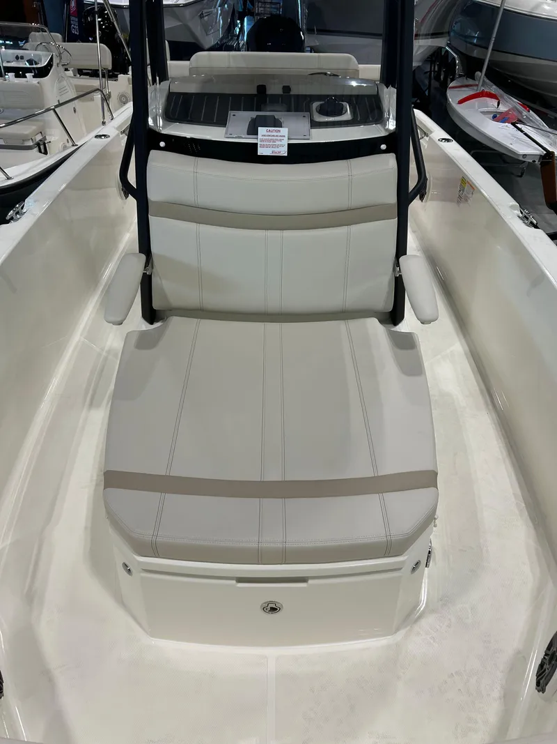 Slide: The Image of 2025 Boston Whaler 220 Dauntless boat interior with cushioned seating and console. - 12